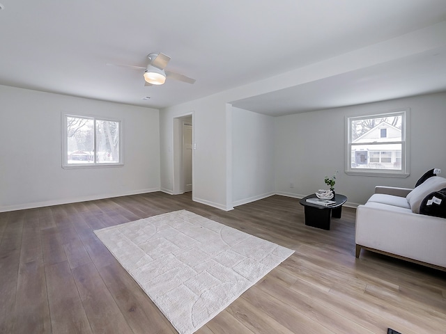 unfurnished living room with wood-type flooring, a healthy amount of sunlight, and ceiling fan