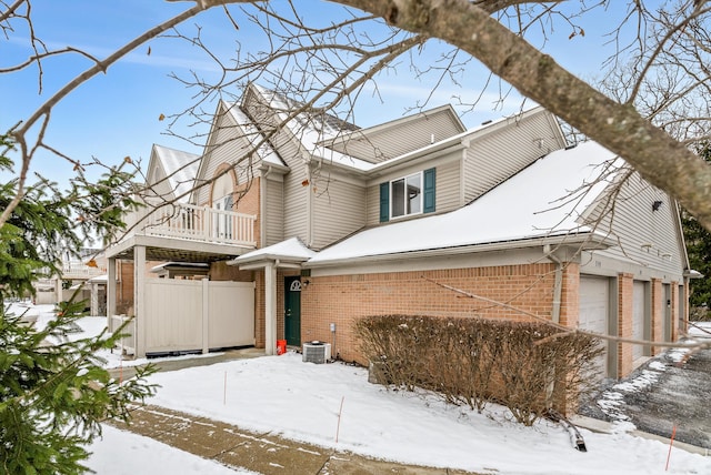 view of front of property with a balcony, central AC unit, and a garage