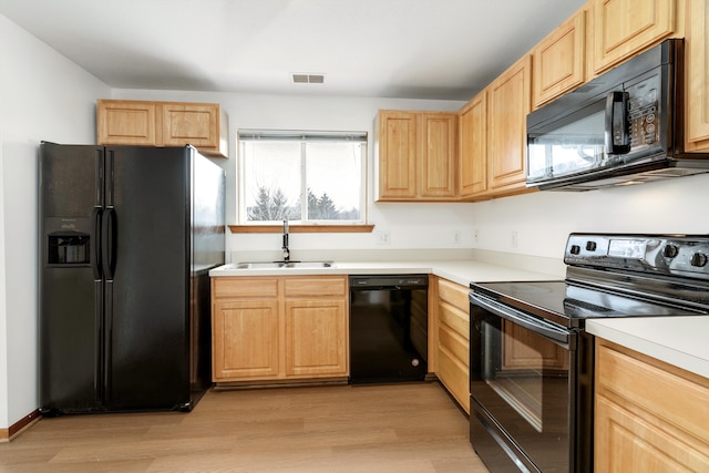 kitchen with black appliances, light hardwood / wood-style floors, sink, and light brown cabinets