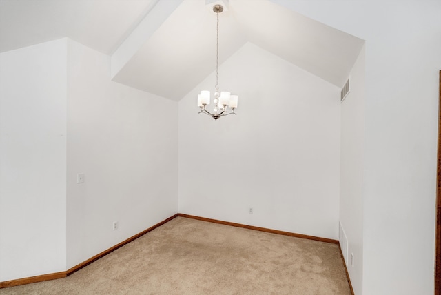 carpeted empty room featuring lofted ceiling and an inviting chandelier