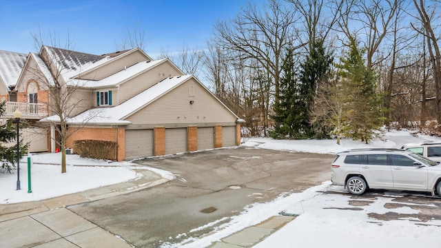 view of snowy exterior with a garage