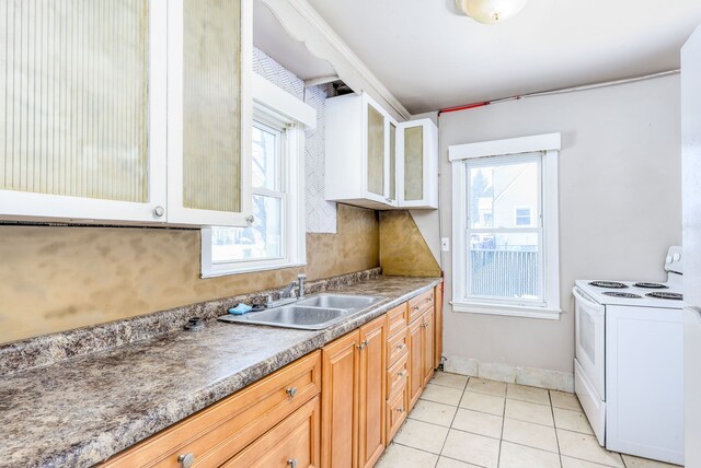 kitchen with sink, a wealth of natural light, light tile patterned floors, and white electric range