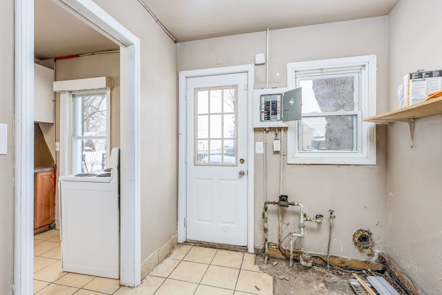 doorway to outside with washer / clothes dryer, light tile patterned floors, and electric panel