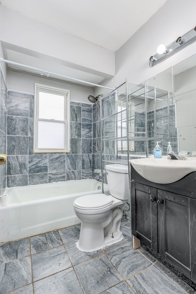 full bathroom featuring vanity, tiled shower / bath combo, and toilet