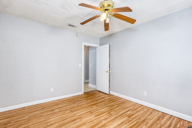 spare room featuring a textured ceiling, light hardwood / wood-style flooring, and ceiling fan