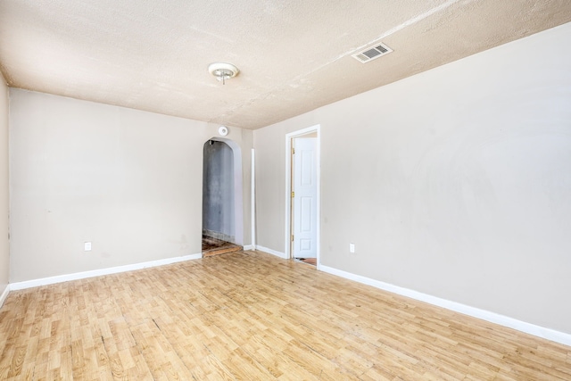 unfurnished room featuring a textured ceiling and light hardwood / wood-style floors