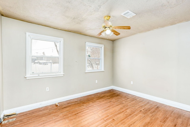 empty room with ceiling fan, a textured ceiling, and light hardwood / wood-style flooring