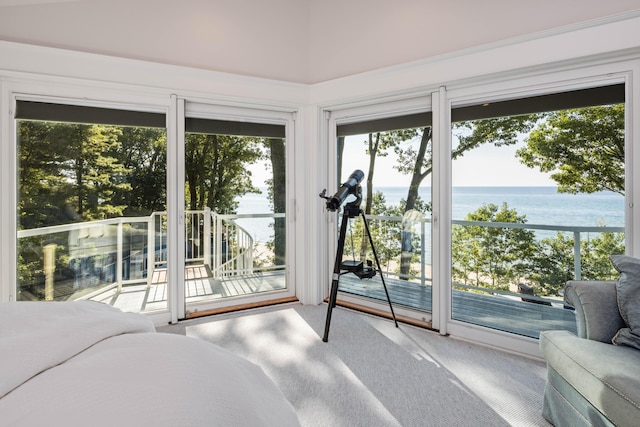 carpeted bedroom with a water view and access to exterior