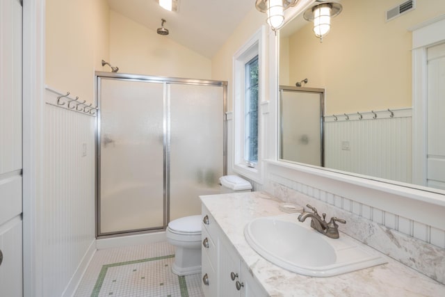 bathroom featuring a stall shower, visible vents, lofted ceiling, a wainscoted wall, and vanity