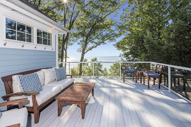 wooden deck featuring a water view and an outdoor living space