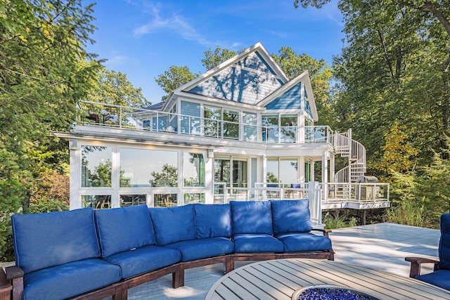 rear view of house featuring a balcony, a deck, stairway, and an outdoor living space