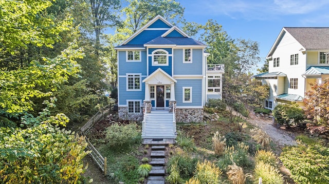 view of front of home with stone siding and stairway