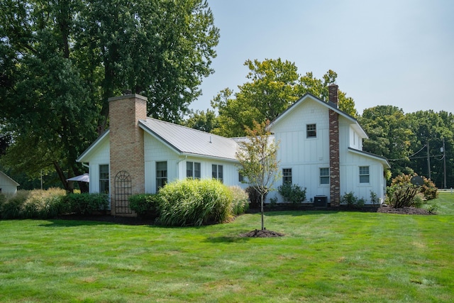 back of house with a yard and central AC