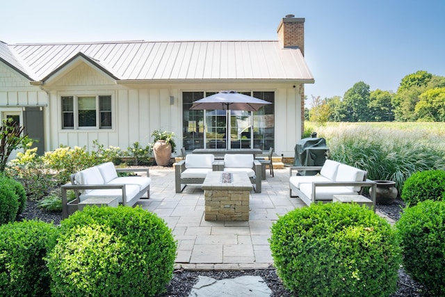 view of patio with grilling area and an outdoor living space with a fire pit