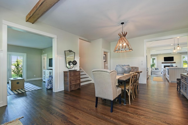 dining area with beam ceiling, a chandelier, a fireplace, and dark wood-type flooring