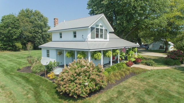 view of side of property featuring covered porch and a yard