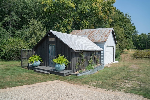 view of outdoor structure featuring a lawn and a garage