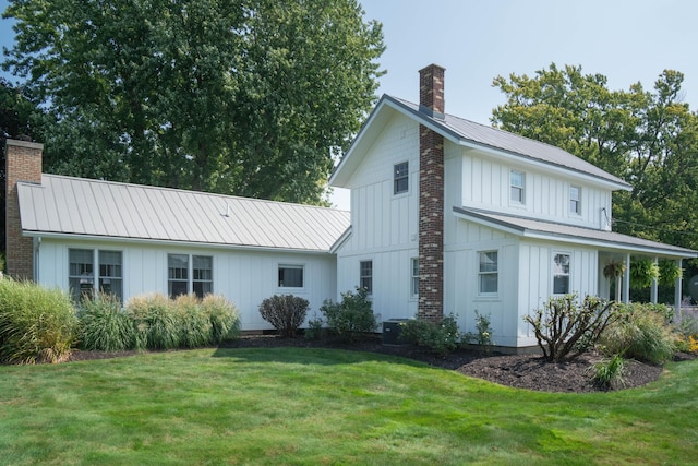 back of house featuring central AC unit and a lawn