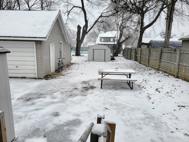 yard layered in snow with a storage shed