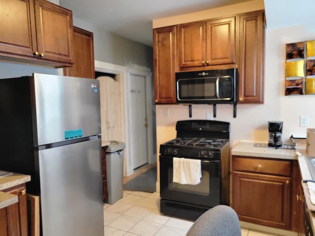 kitchen with light tile patterned floors and black appliances