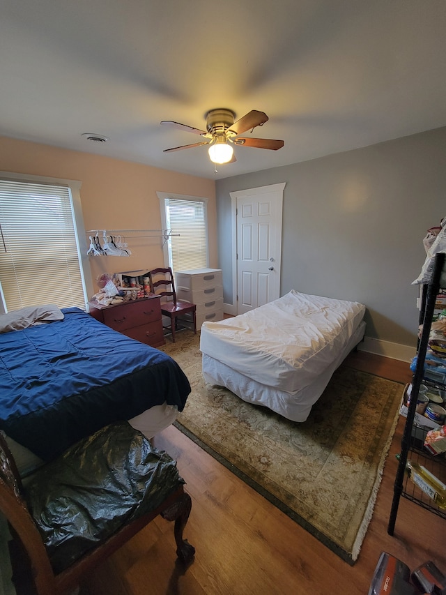 bedroom with ceiling fan and hardwood / wood-style flooring