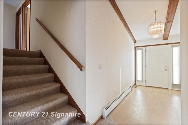 entrance foyer featuring wood-type flooring, baseboard heating, and an inviting chandelier