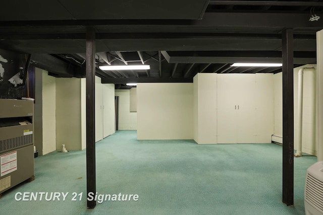 basement featuring baseboard heating, heating unit, and light carpet