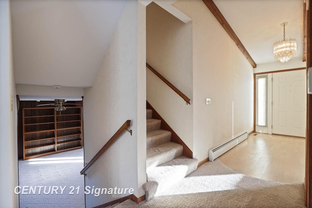 entryway with carpet, ceiling fan with notable chandelier, and a baseboard heating unit