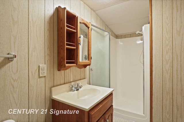 bathroom with vanity, wooden walls, walk in shower, and lofted ceiling