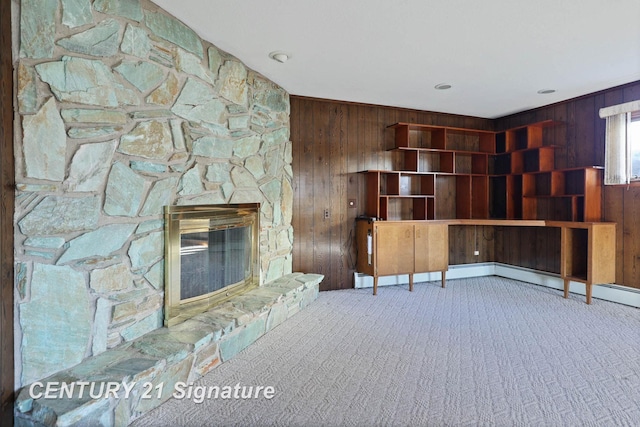 unfurnished living room with wood walls, a fireplace, and carpet