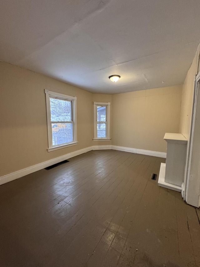 unfurnished room with dark hardwood / wood-style flooring