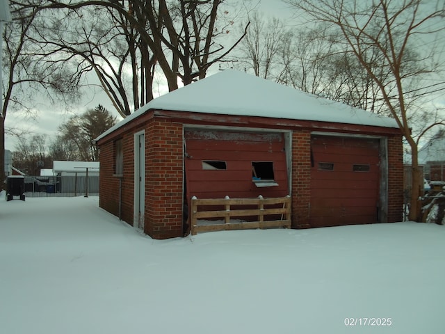 snow covered structure with a garage