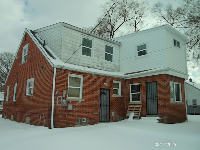 view of snow covered back of property