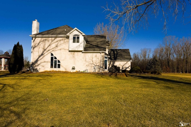 rear view of house featuring a yard