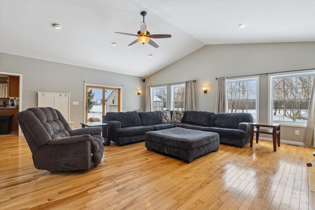 living room featuring light hardwood / wood-style flooring, ceiling fan, lofted ceiling, and sink