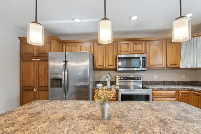 kitchen with stainless steel appliances, pendant lighting, and brown cabinetry