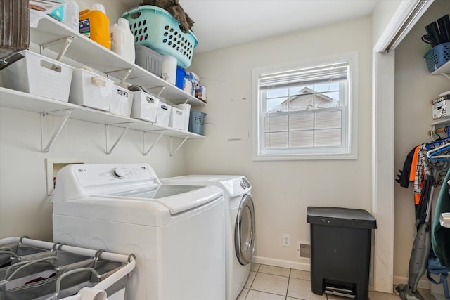 washroom with laundry area, independent washer and dryer, light tile patterned flooring, and baseboards