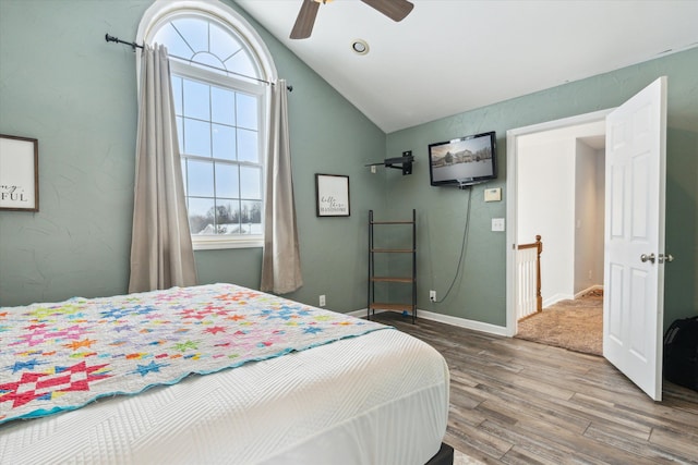 bedroom with vaulted ceiling, wood finished floors, a ceiling fan, and baseboards