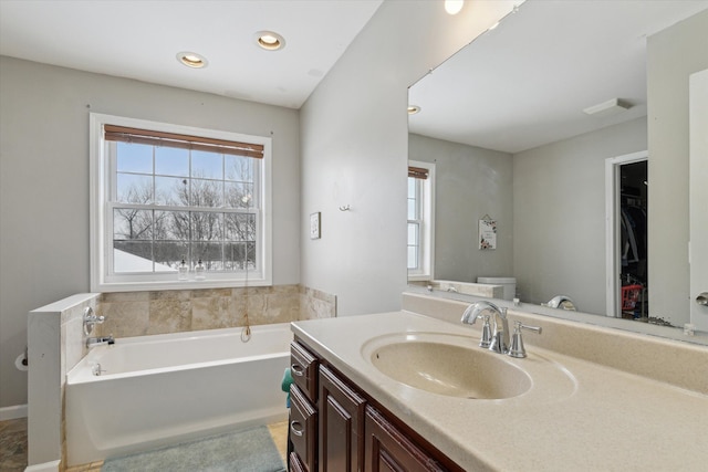 full bathroom with vanity, a wealth of natural light, a garden tub, and visible vents