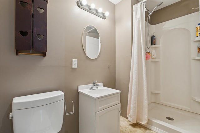 bathroom with toilet, a stall shower, and vanity