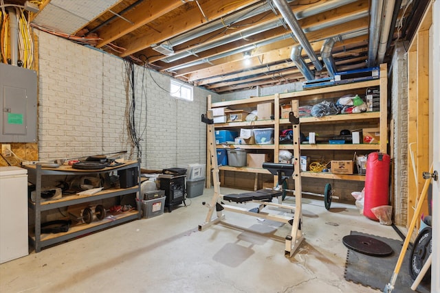 basement featuring electric panel and brick wall