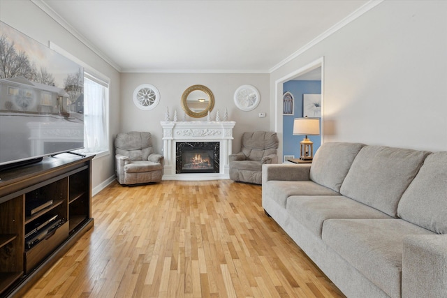 living room featuring a high end fireplace, light hardwood / wood-style flooring, and ornamental molding