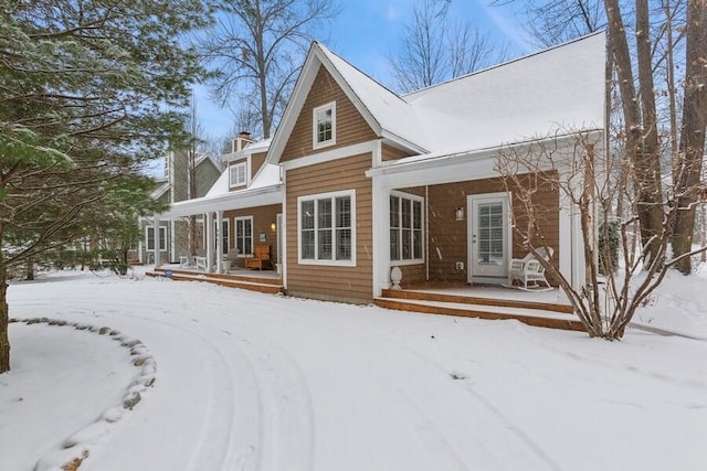 snow covered house with a wooden deck