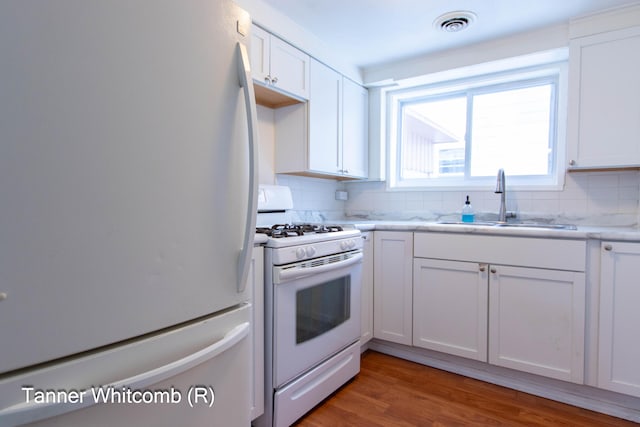 kitchen with sink, decorative backsplash, white appliances, and white cabinetry