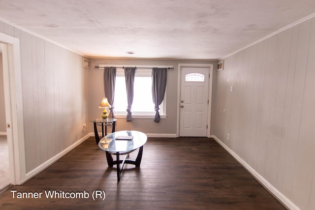 entrance foyer with ornamental molding and dark hardwood / wood-style flooring