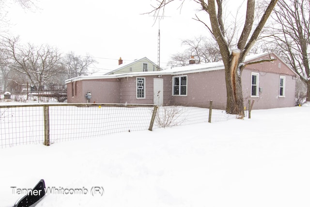 view of snow covered rear of property