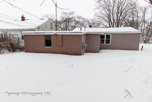 view of snow covered rear of property