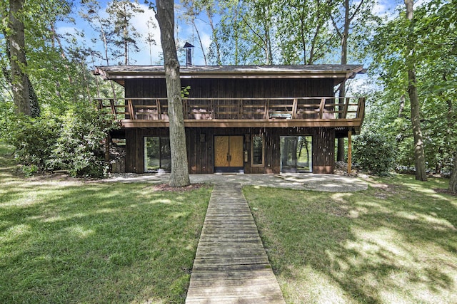 rear view of property with a yard and a wooden deck