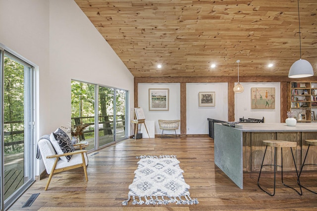 interior space featuring pendant lighting, hardwood / wood-style floors, high vaulted ceiling, wood ceiling, and a breakfast bar area