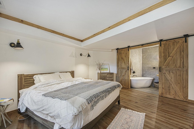 bedroom featuring dark hardwood / wood-style flooring and a barn door